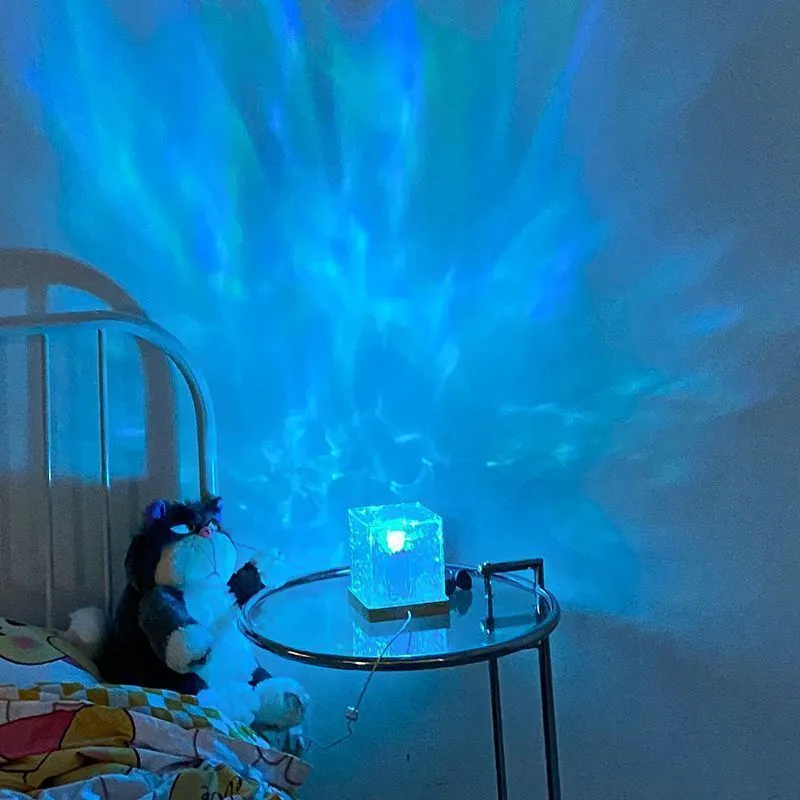 LED water ripple projection crystal table lamp with remote control on wooden surface