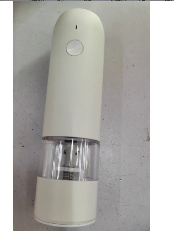 Black and silver rechargeable electric pepper grinder with clear acrylic body on a kitchen counter