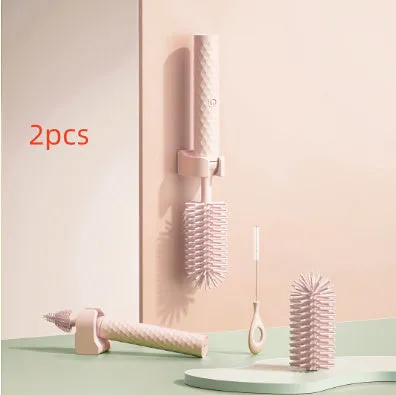 Pink and green electric rotating silicone bottle brush set for cleaning baby bottles and cups.