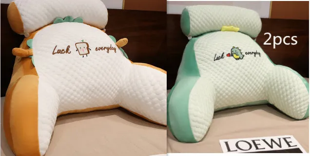 Large triangle-shaped reading cushion with embroidered design on a sofa.