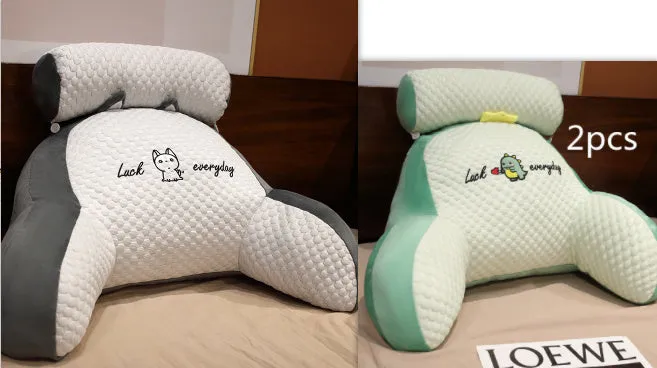 Large triangle-shaped reading cushion with embroidered design on a sofa.