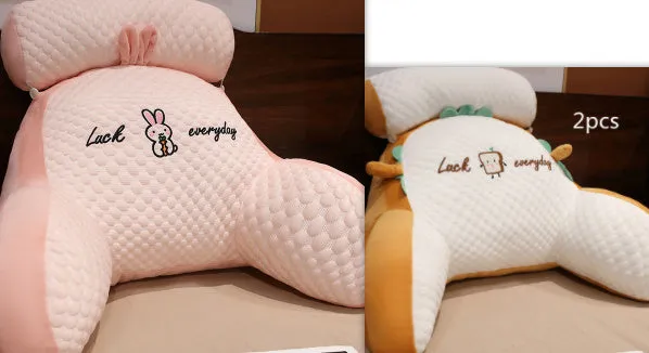 Large triangle-shaped reading cushion with embroidered design on a sofa.