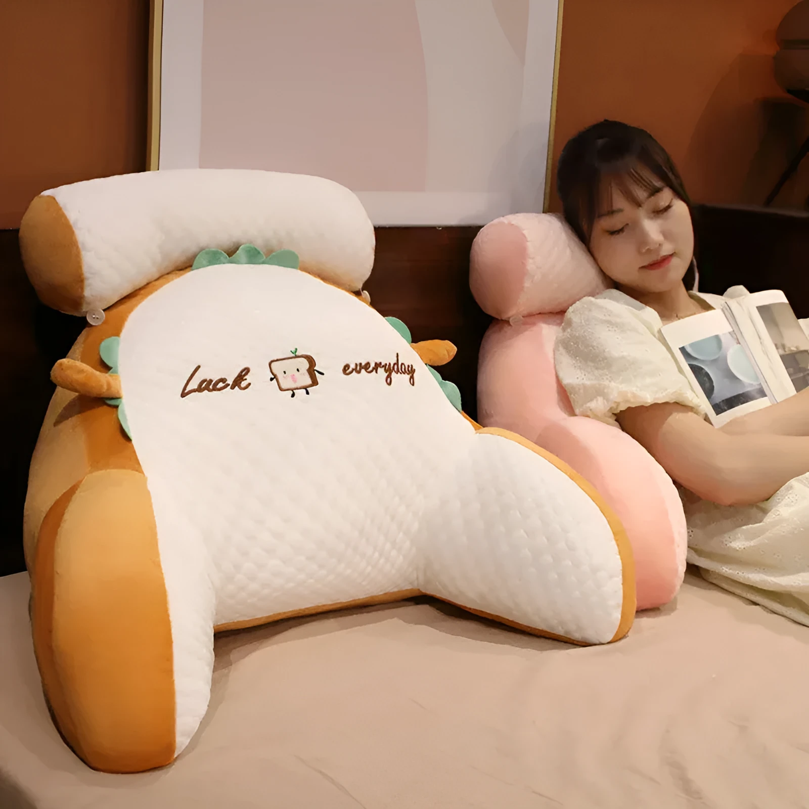 Large triangle-shaped reading cushion with embroidered design on a sofa.