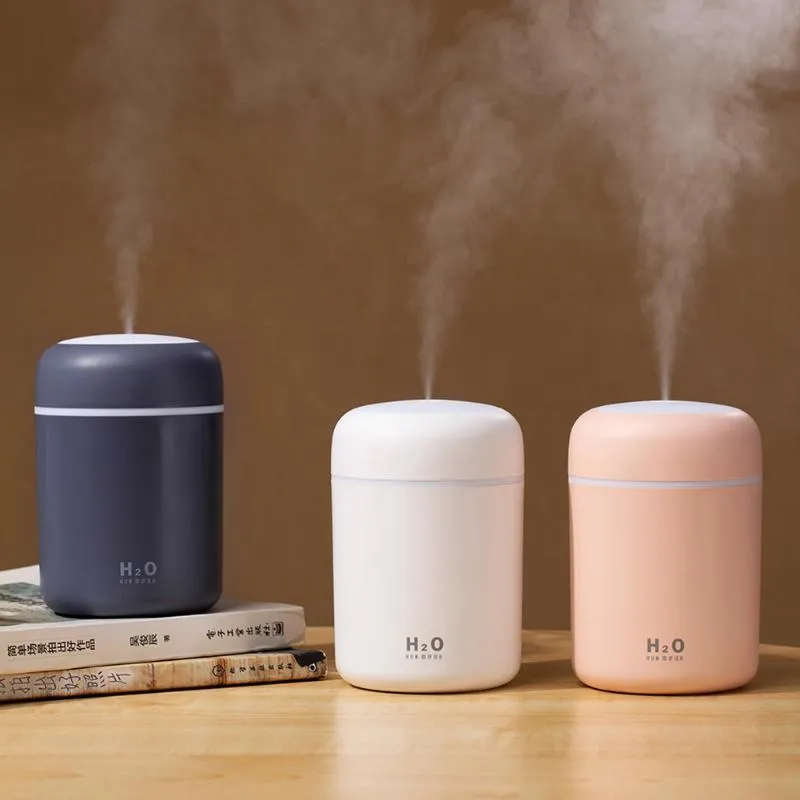 Pink, white, and navy blue USB mini silent humidifier with LED lights on a desk