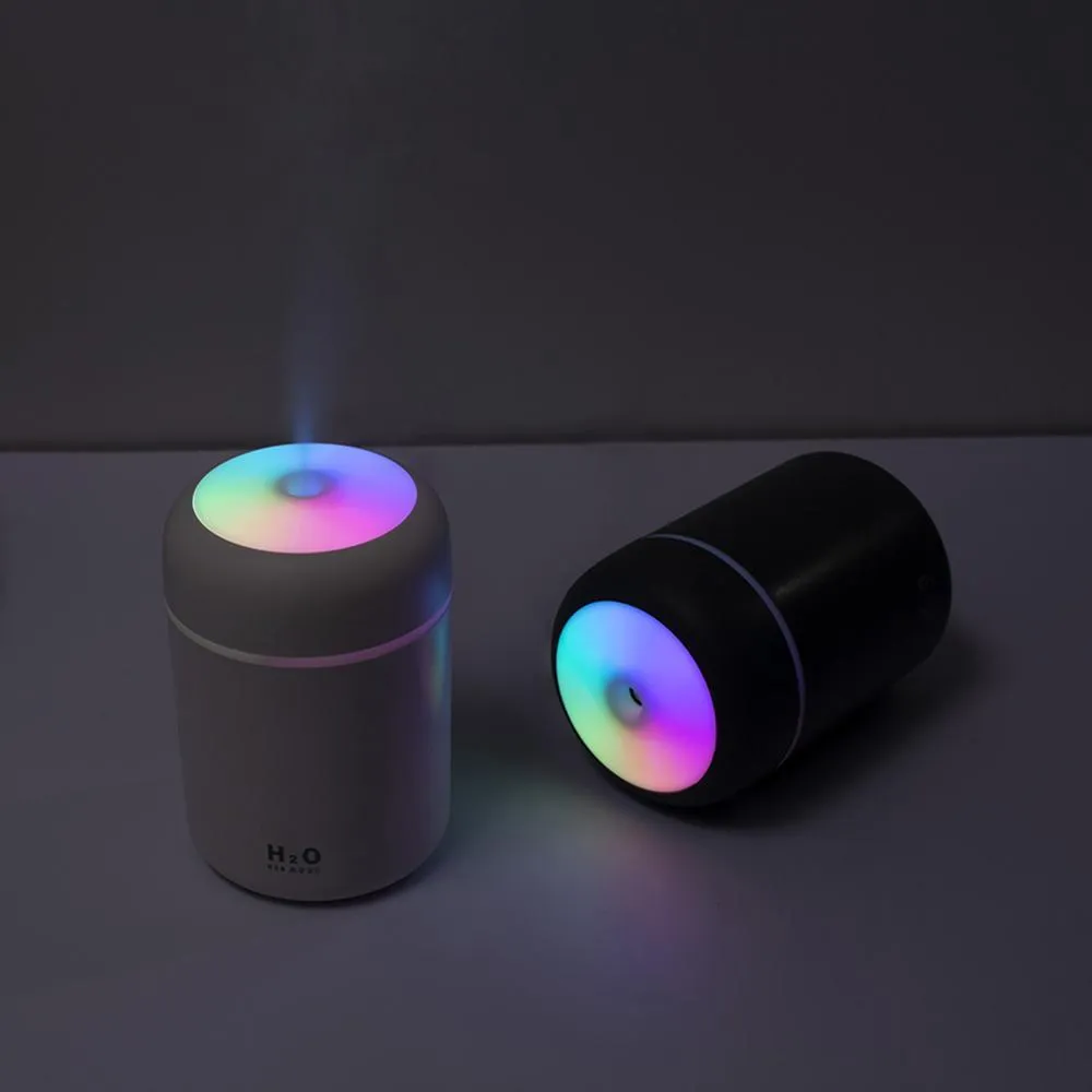 Pink, white, and navy blue USB mini silent humidifier with LED lights on a desk