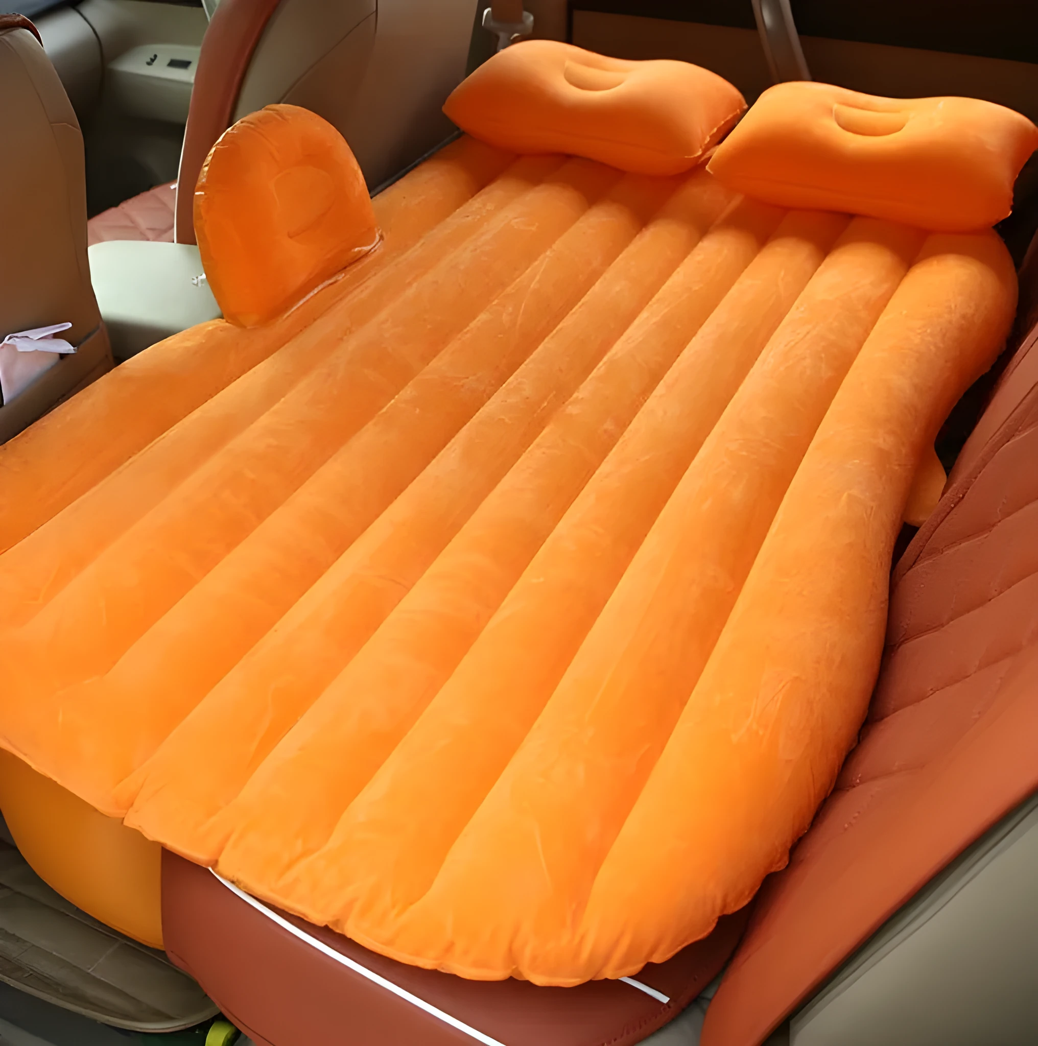 Black inflatable car bed with flocked material laid out in a five-seater vehicle boot.