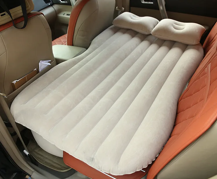Black inflatable car bed with flocked material laid out in a five-seater vehicle boot.