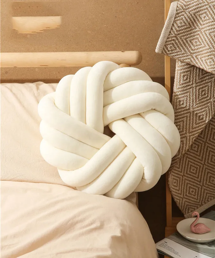Square decorative cushion with knotted ball design in velvet fabric, shown in caramel colour