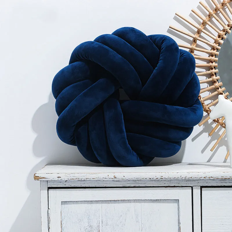 Square decorative cushion with knotted ball design in velvet fabric, shown in caramel colour