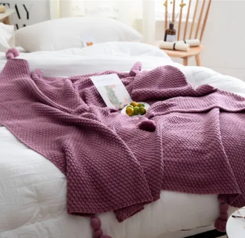 Simple modern fringed knit acrylic blanket in beige colour laid on a sofa, showing 130x170cm size.