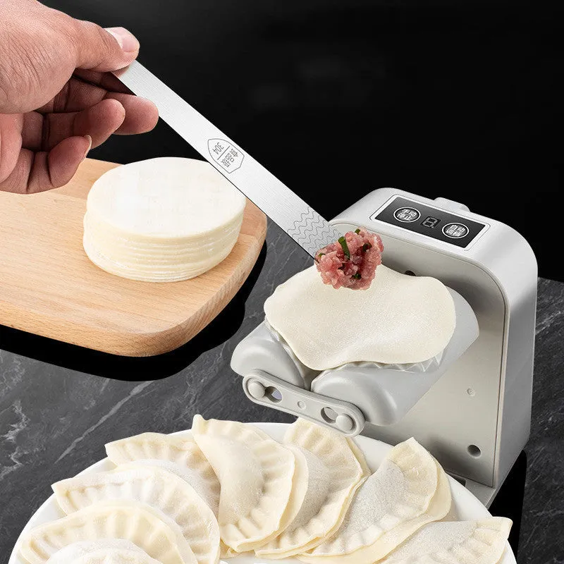 White automatic electric dumpling maker machine with USB cable on a kitchen counter.