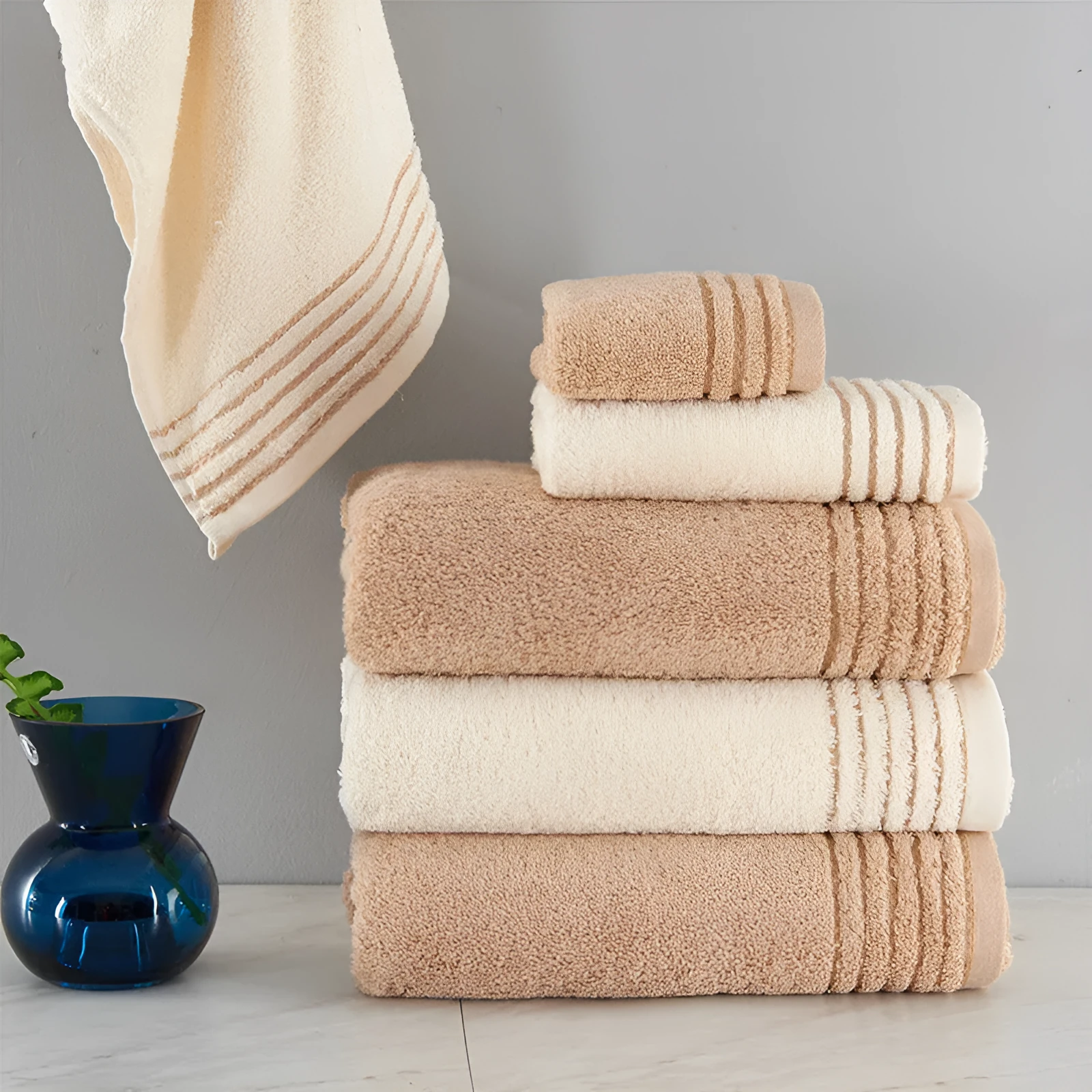 Beige and brown cotton towel set showing small, hand, and bath towel sizes.