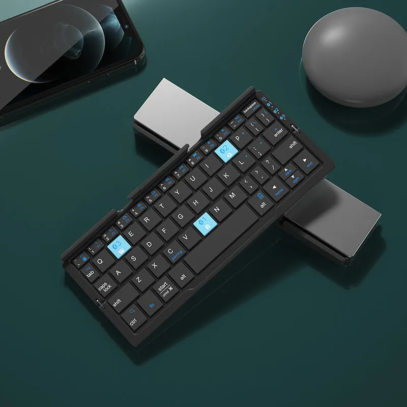 Folded aluminium Bluetooth keyboard showing compact size next to unfolded version with tablet on stand