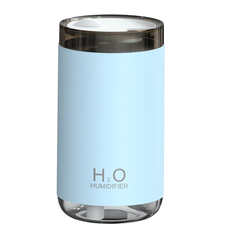 White USB humidifier emitting jellyfish-shaped smoke ring mist with warm night light glow on a table