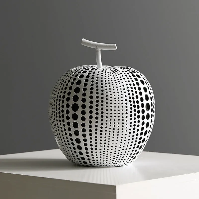 White and black resin apple and pear decorations showing high and low profile models on a wooden surface
