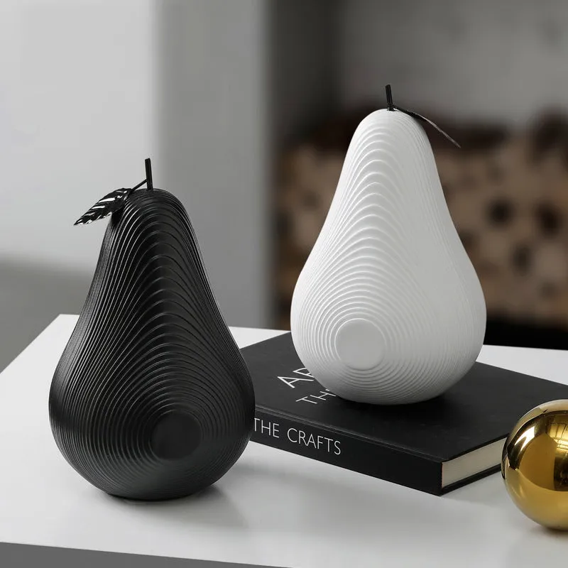 White and black resin apple and pear decorations showing high and low profile models on a wooden surface