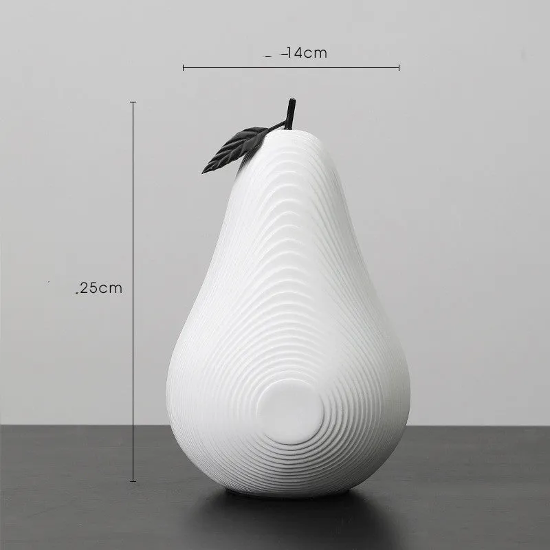 White and black resin apple and pear decorations showing high and low profile models on a wooden surface