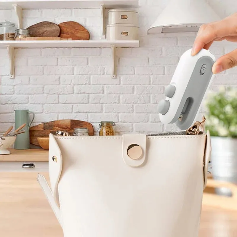 Blue and white handheld USB rechargeable heat sealer with built-in cutter for sealing food bags.