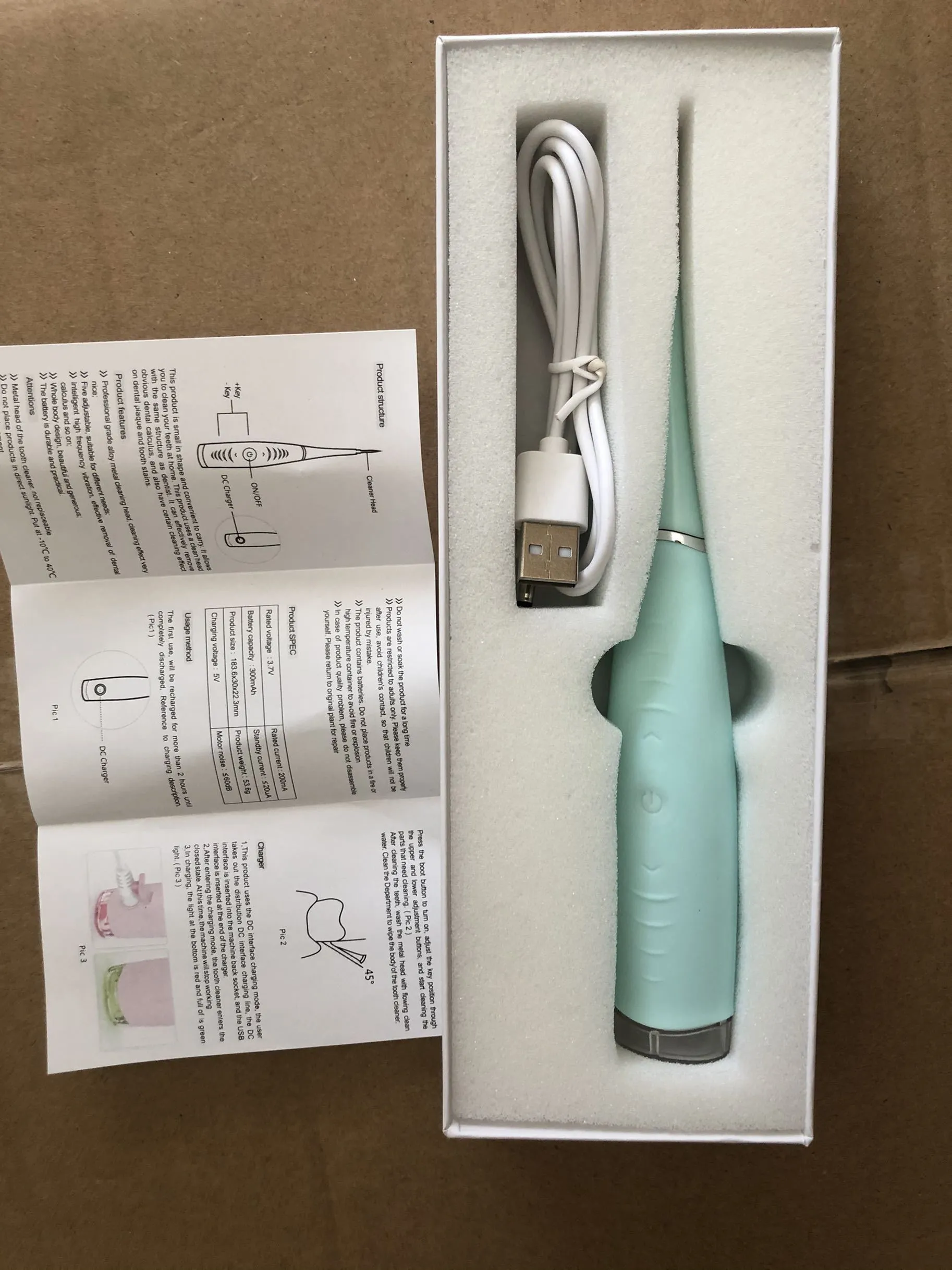 Pink or blue waterproof electric toothbrush care tool for removing dental calculus on a bathroom counter.