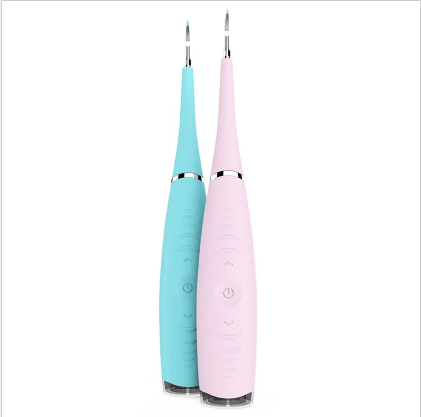 Pink or blue waterproof electric toothbrush care tool for removing dental calculus on a bathroom counter.