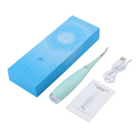 Pink or blue waterproof electric toothbrush care tool for removing dental calculus on a bathroom counter.
