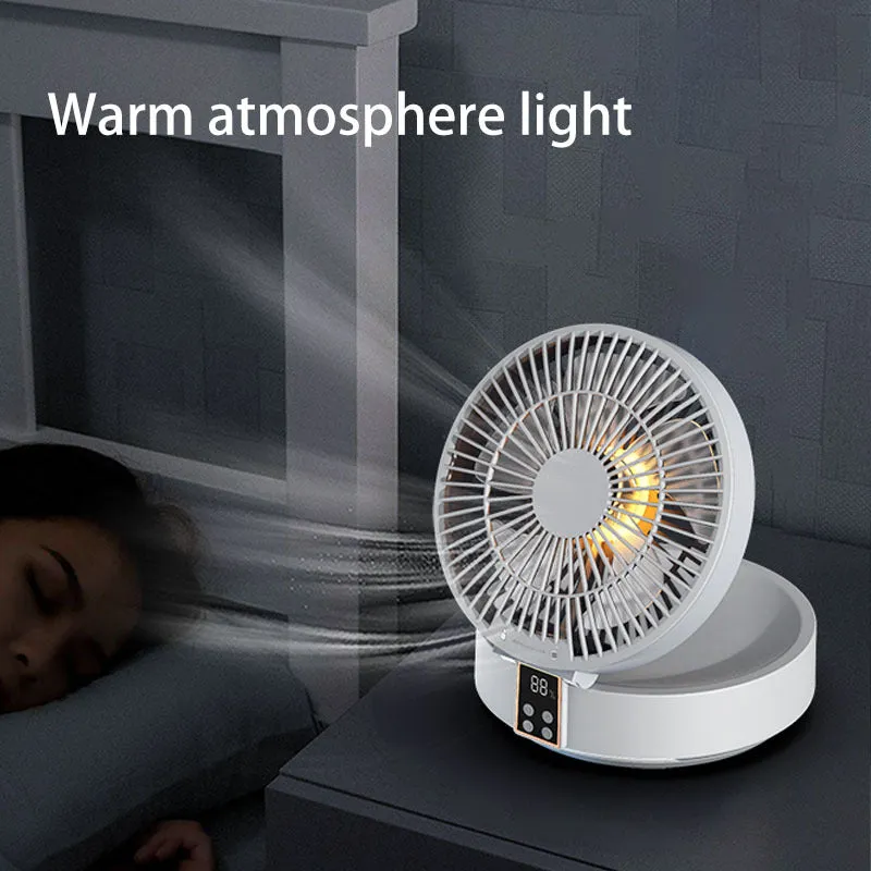 White portable folding electric fan with night light and remote control on a desk