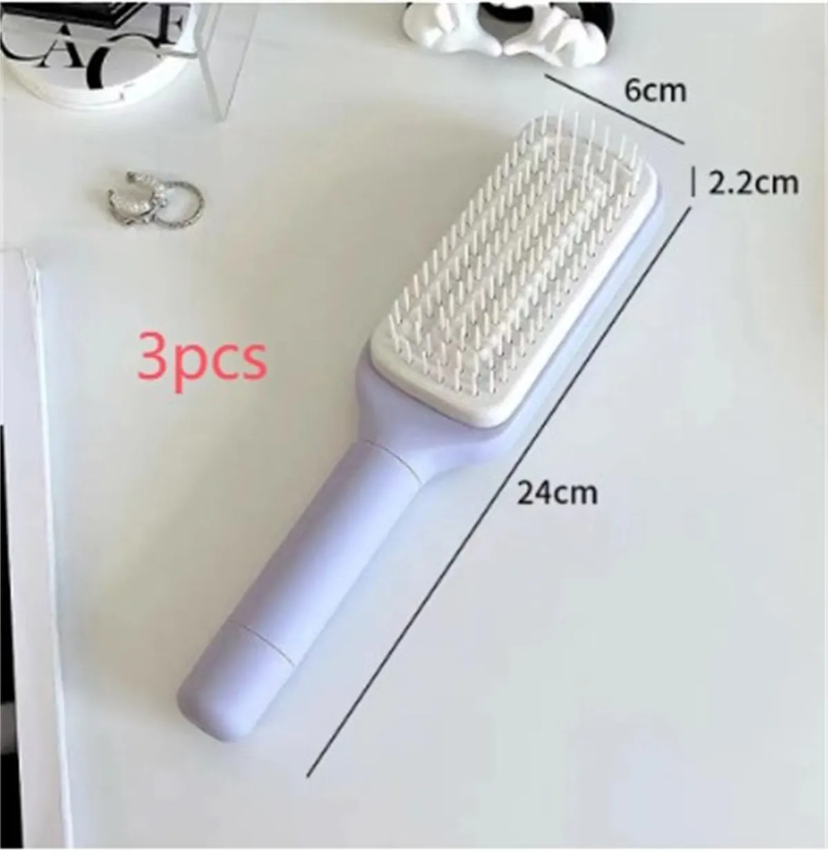 Purple and grey self-cleaning hair brushes with rotating handles and anti-static teeth.