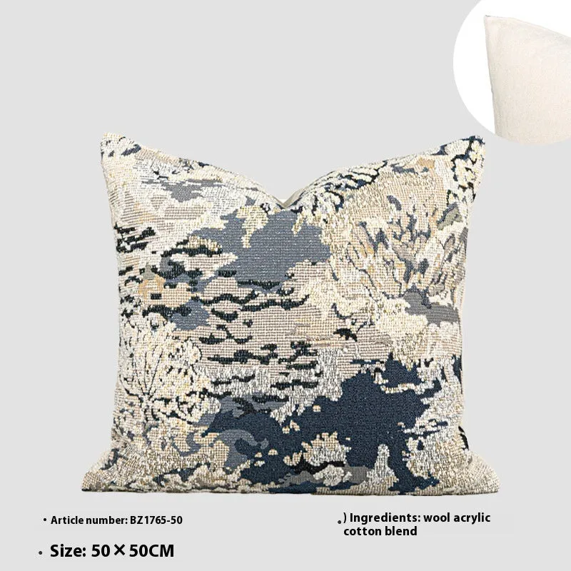 Blue floral antique pattern wool blend cushion cover and feather velvet pillow on a sofa.