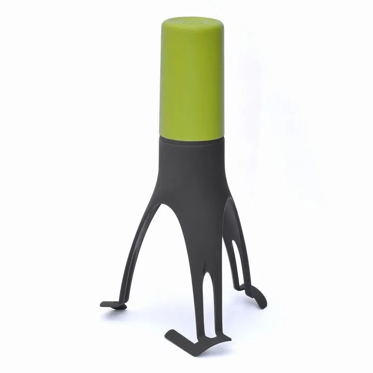 Green and grey automatic Stirr utensil for hands-free mixing in a cooking pot.