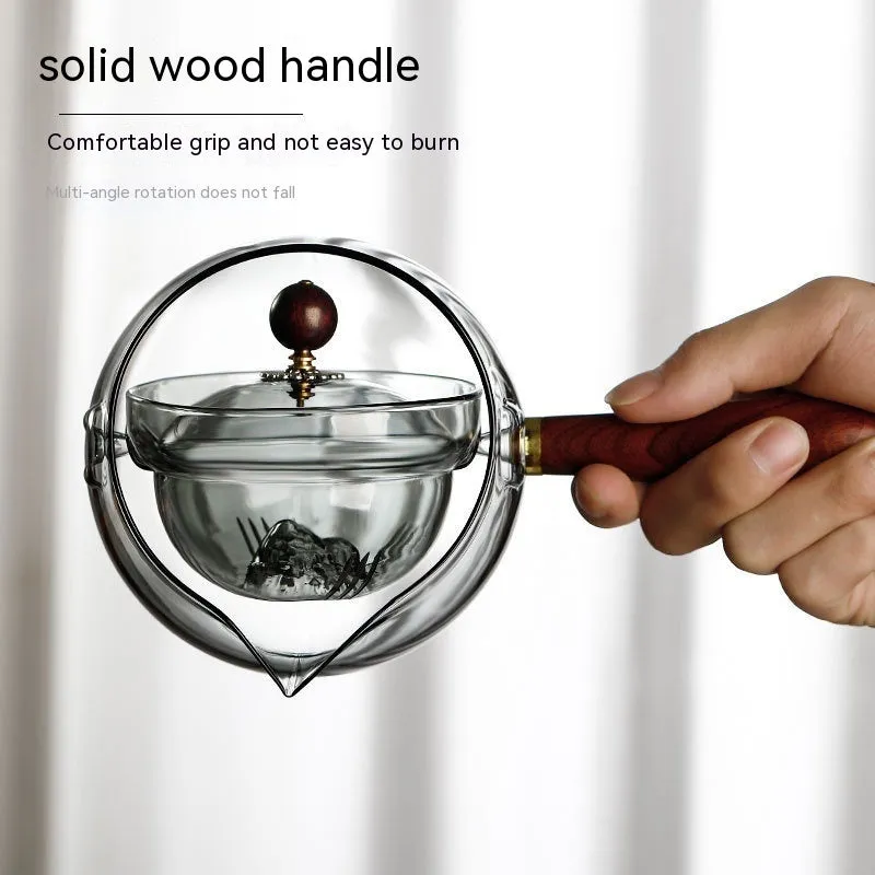 Transparent rotating glass teapot with wooden handle and integrated tea infuser