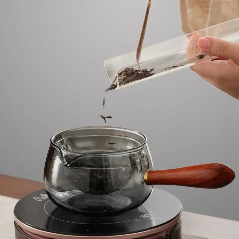 Transparent rotating glass teapot with wooden handle and integrated tea infuser