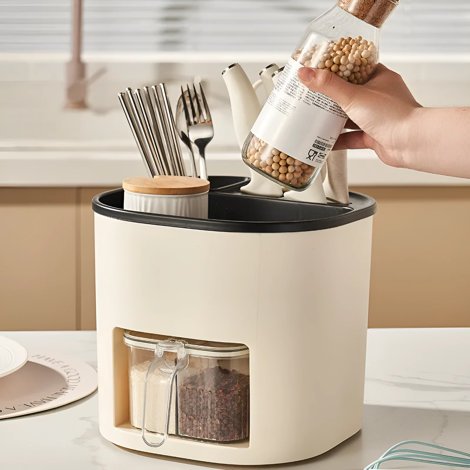 White rotating kitchen storage bucket with four-compartment spice box lid next to cutlery.