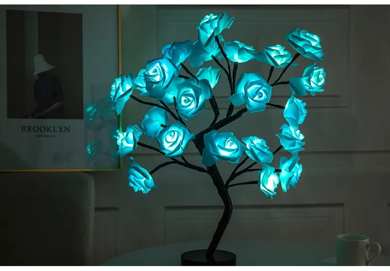White and red rose flower shaped USB battery LED table lamp with warm white light on a table.