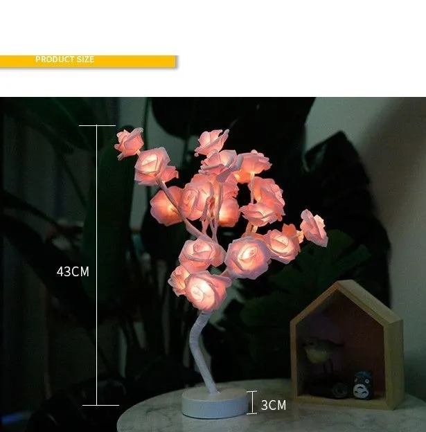 White and red rose flower shaped USB battery LED table lamp with warm white light on a table.