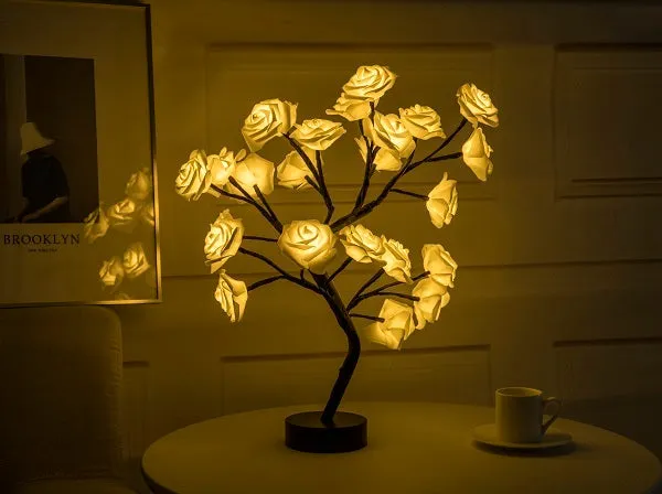 White and red rose flower shaped USB battery LED table lamp with warm white light on a table.