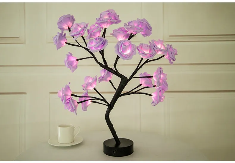 White and red rose flower shaped USB battery LED table lamp with warm white light on a table.