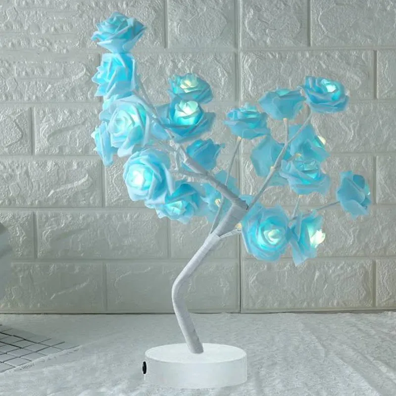 White and red rose flower shaped USB battery LED table lamp with warm white light on a table.