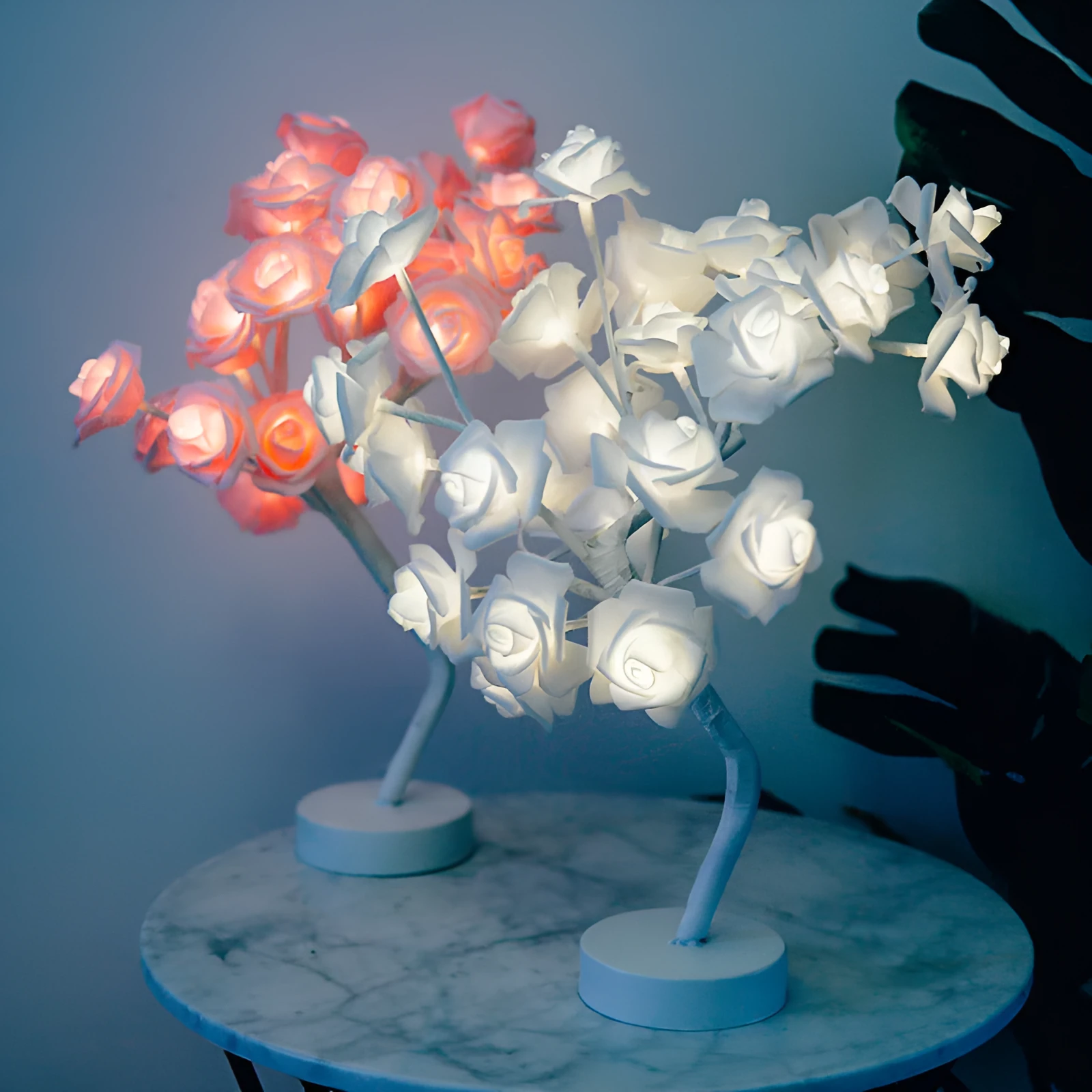 White and red rose flower shaped USB battery LED table lamp with warm white light on a table.