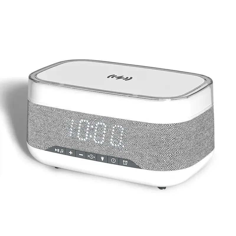White multifunctional alarm clock with Bluetooth speaker and wireless charging pad on a bedside table.
