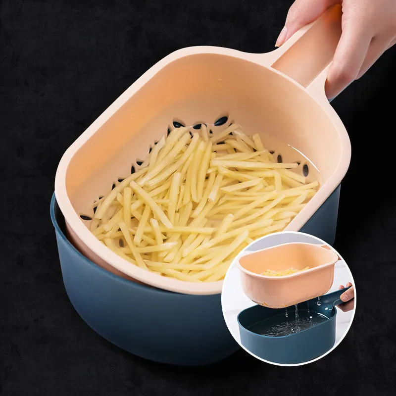 Dark blue vegetable cutter with four stainless steel blades, drain basket, and hand guard on a kitchen worktop