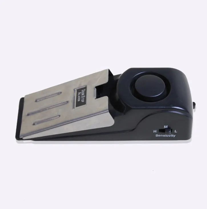 Black portable door stop alarm with wedge shape and stainless steel sensor cover.