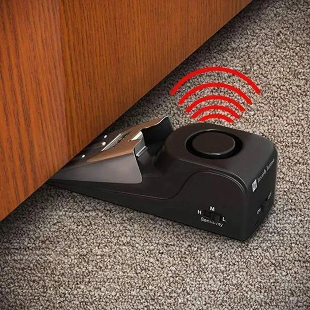Black portable door stop alarm with wedge shape and stainless steel sensor cover.