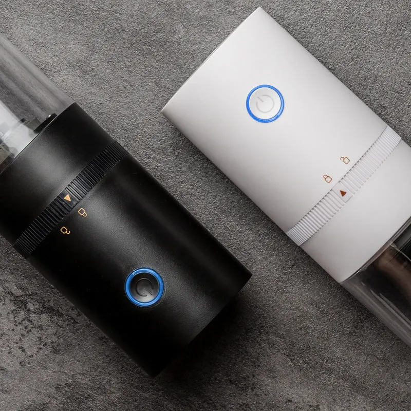 Black and white portable USB-C electric coffee grinder with transparent chamber on a kitchen counter