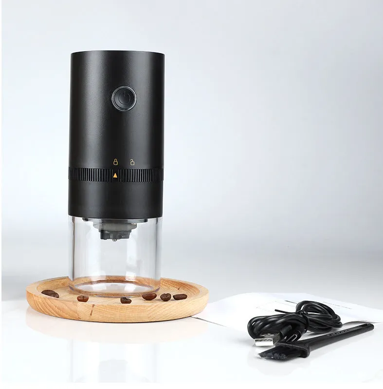 Black and white portable USB-C electric coffee grinder with transparent chamber on a kitchen counter