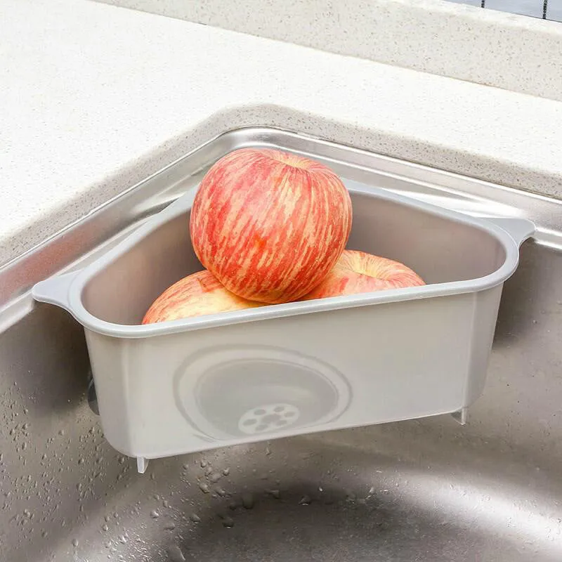Beige and blue plastic triangle sink storage rack with suction cups holding a sponge