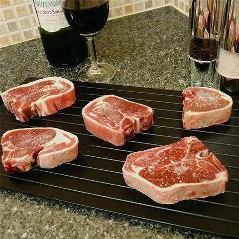 Black aluminium quick defrosting tray for thawing frozen meat and food without electricity.