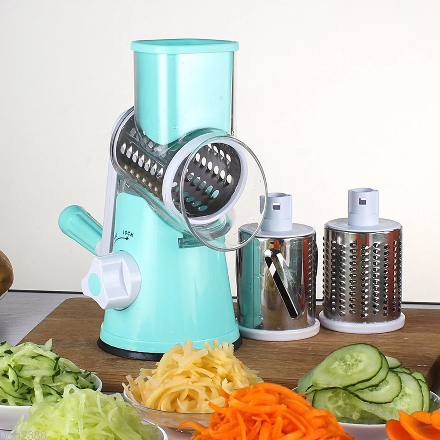 Round vegetable mandoline slicer with stainless steel blades and suction base in green colour