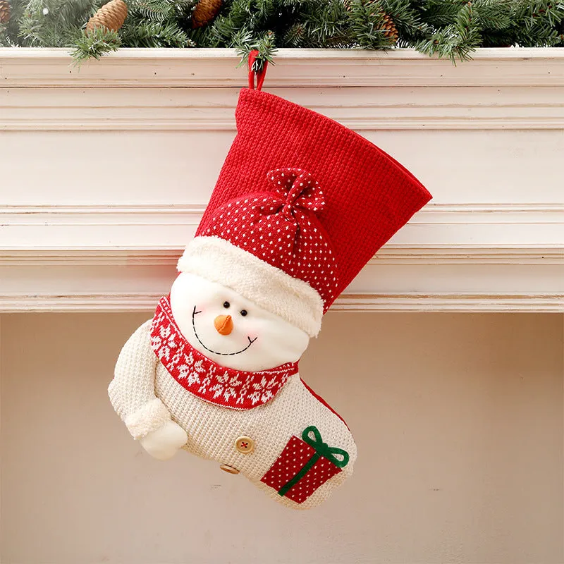 Large red and white knitted Christmas stocking with Santa Claus design hanging on fireplace