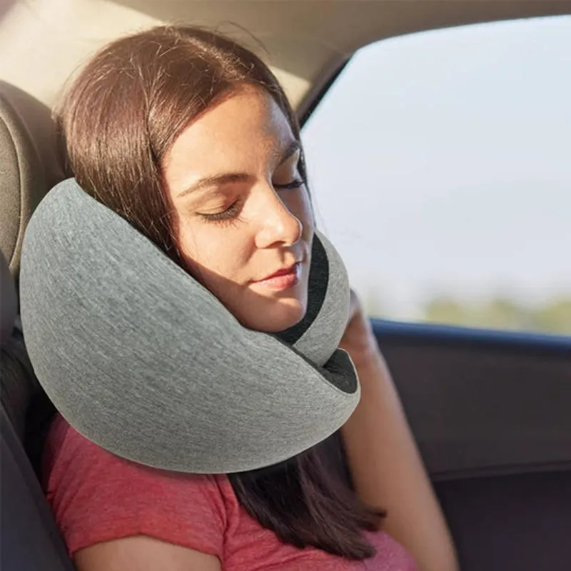Navy blue U-shaped memory foam travel neck pillow rolled up next to its carry bag.