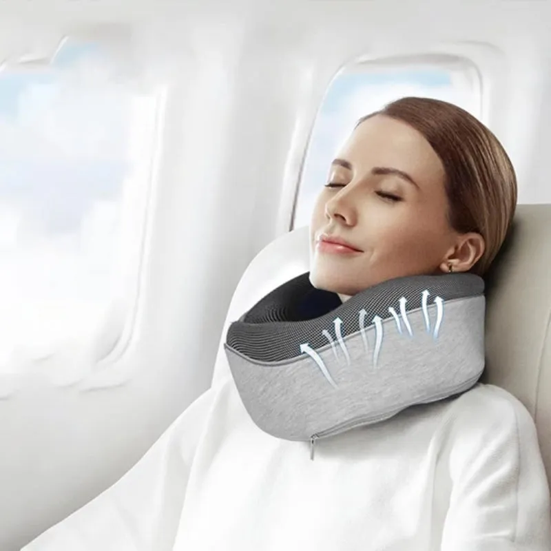Navy blue U-shaped memory foam travel neck pillow rolled up next to its carry bag.